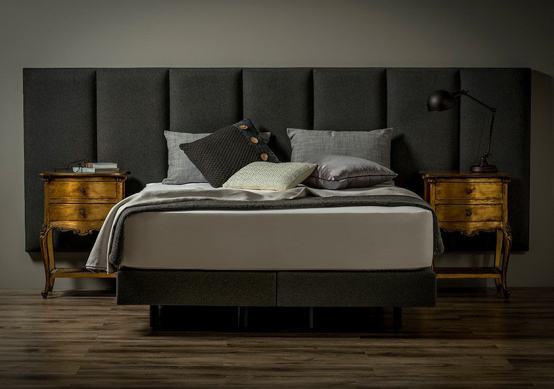 Custom extended headboard combining linen upholstery with 7 upholstered panels